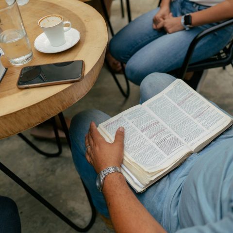 An open Bible during a quiet one-on-one conversation